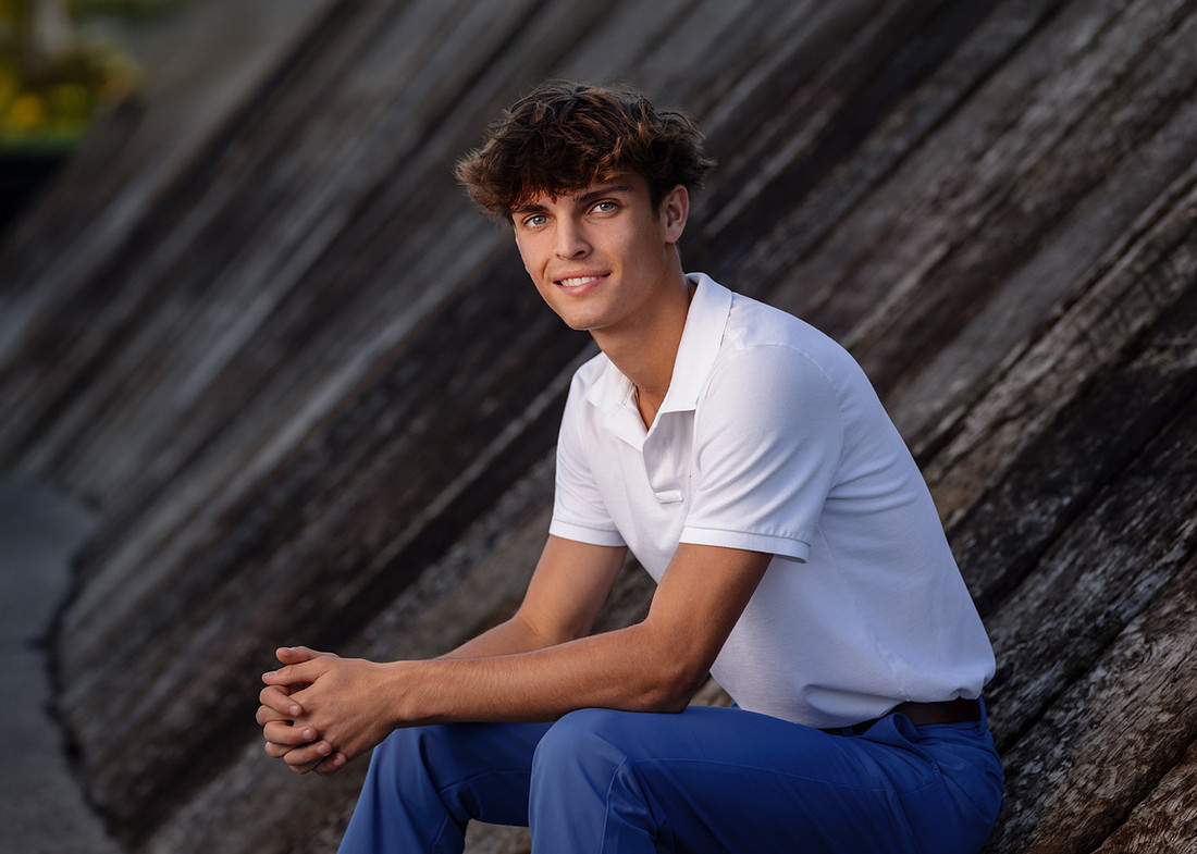 Senior guy in a white polo during summer senior pictures in Noblesville, Indiana