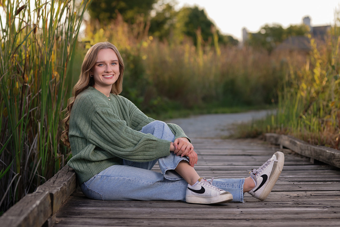 High school senior wearing a green sweater during fall senior pictures in Noblesville, Indiana