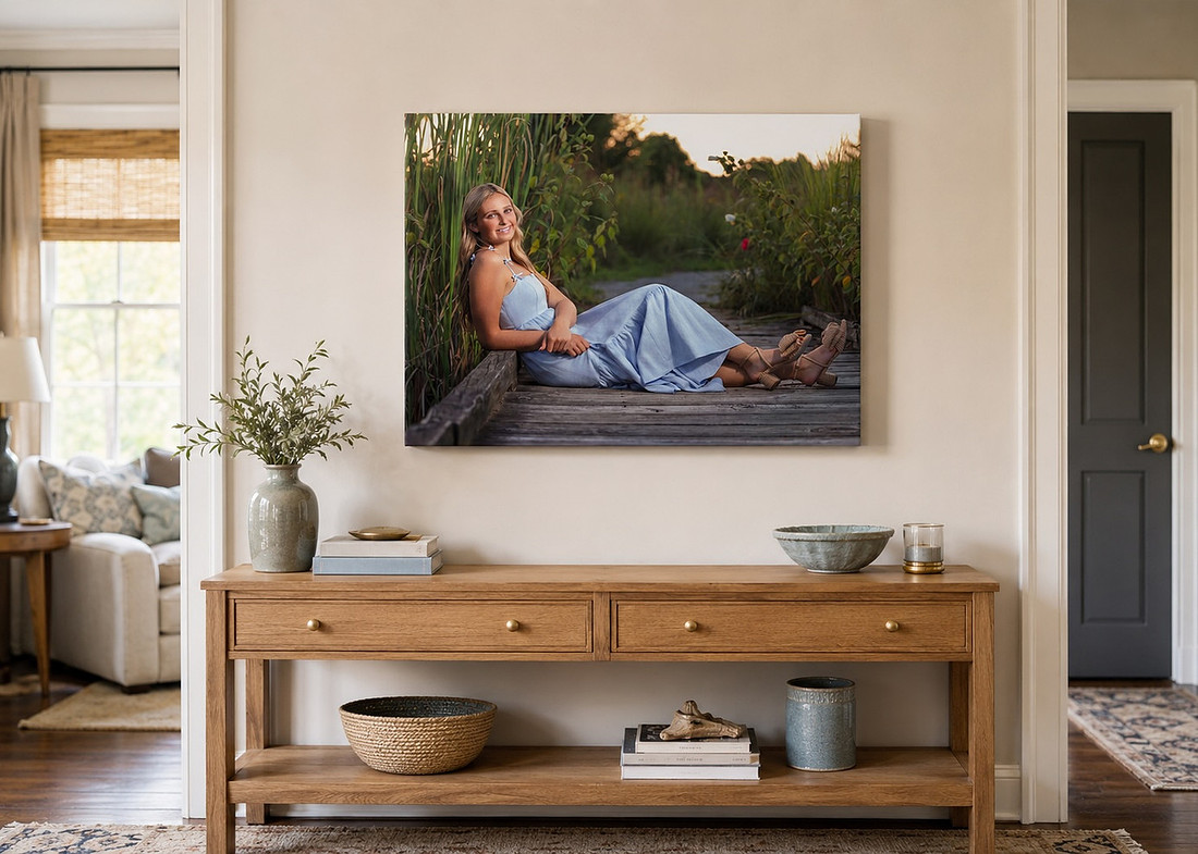 Senior portrait displayed as a 20x24 canvas above a wood console in a family home